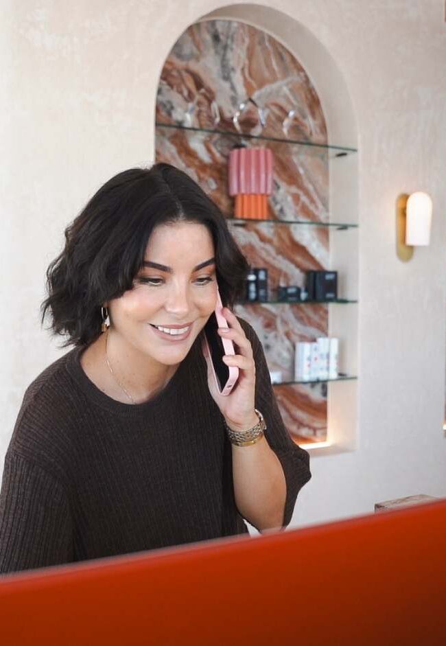 Sisä Skincare team member answering a phone call at the Freshwater, Northern Beaches clinic